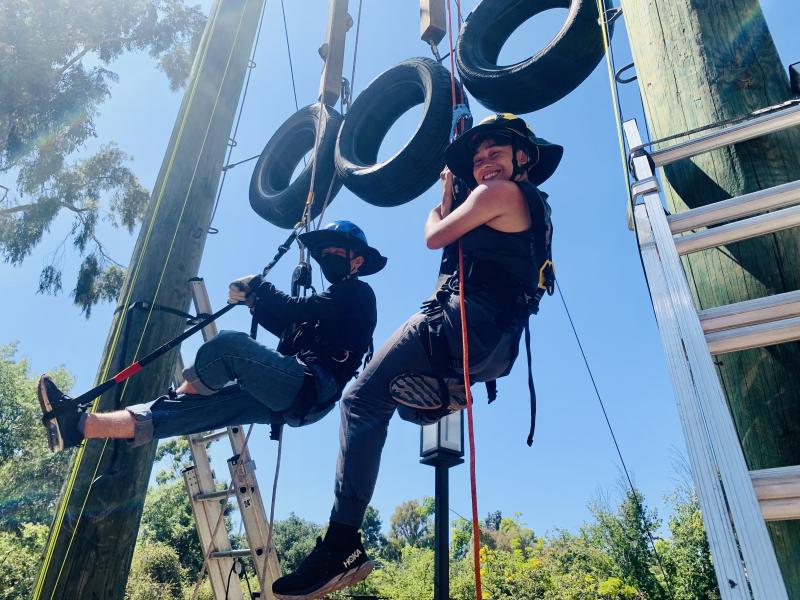 two challenge course student employees on high ropes course