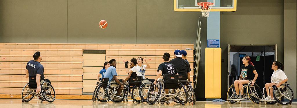 A group of people playing basketball in wheelchairs