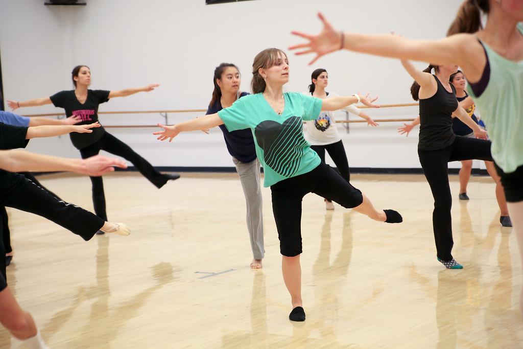 Group of students dancing with arms out and one leg in the air