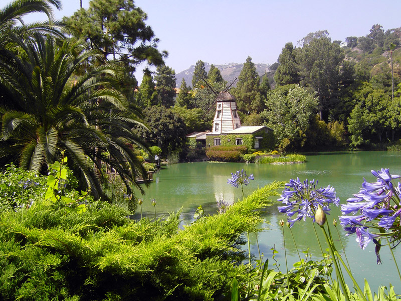 A photo of the Self Realization Fellowship Shrine. A structure is seen overlooking a lake with lots of greenery. 