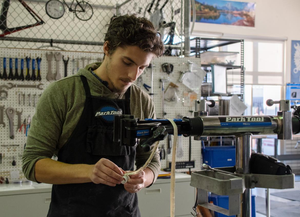 bike shop student employee working on repair