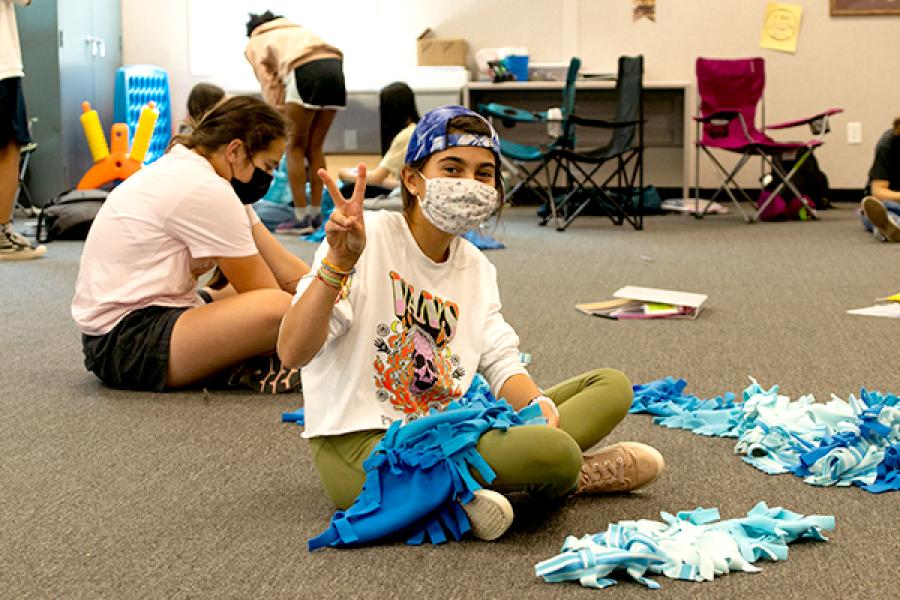 teen sitting on floor working on a craft project