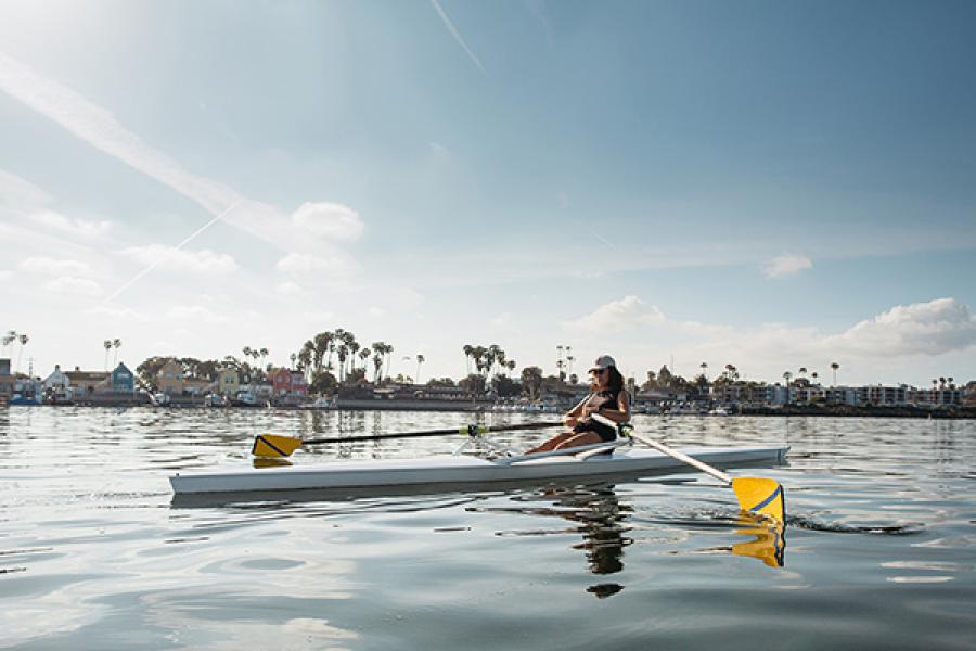 person in single scull rowing boat