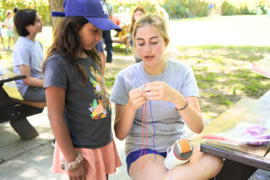 counselor showing camper how to do a craft