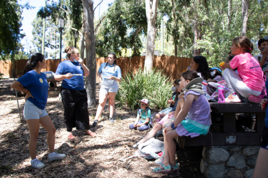 kids and counselor sitting in a circle planning for upcoming theater performance.