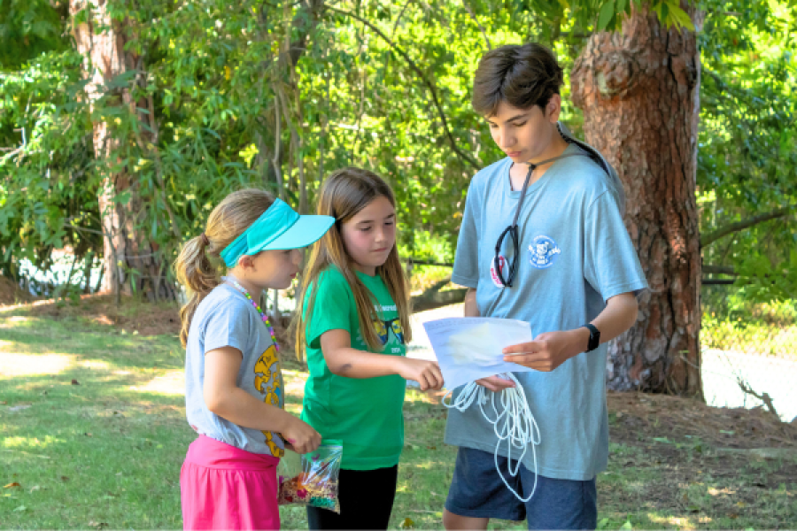 Camp Counselor explaining an activity to two campers