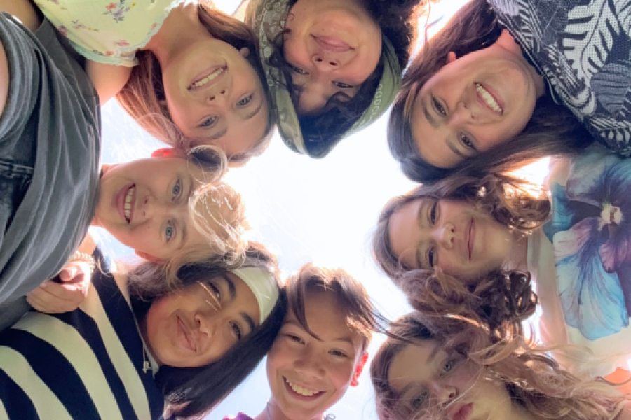 group of kids with arms around each other smiling at the camera